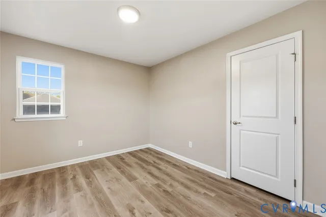 a view of empty room with wooden floor and entryway