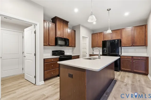 a kitchen with a refrigerator sink and wooden cabinets