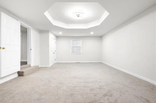 an empty room with a window and closet area