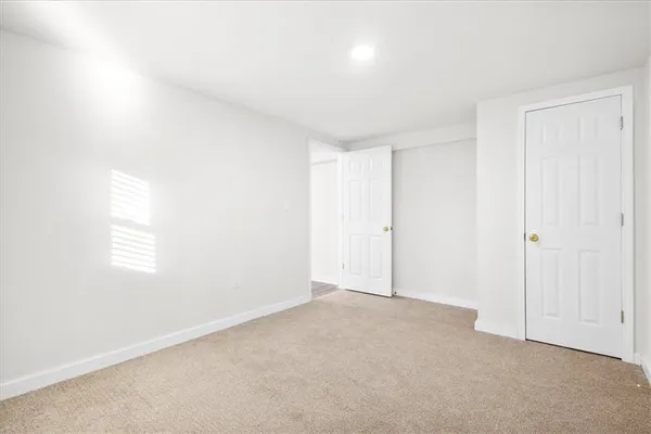 a view of a livingroom with wooden floor and a hallway