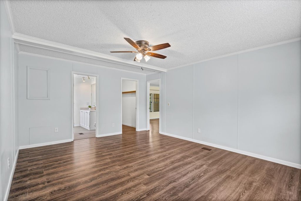 13501 Nutty Brown Road, Unit B Austin, TX 78737 - Photo 5 of 29 A well-lit interior space with rich wood-look flooring and a functional ceiling fan.