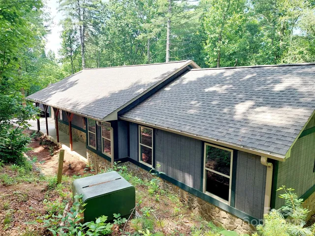 a backyard of a house with large trees and wooden fence