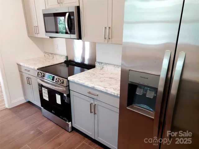 a kitchen with stainless steel appliances granite countertop a stove a microwave and a refrigerator