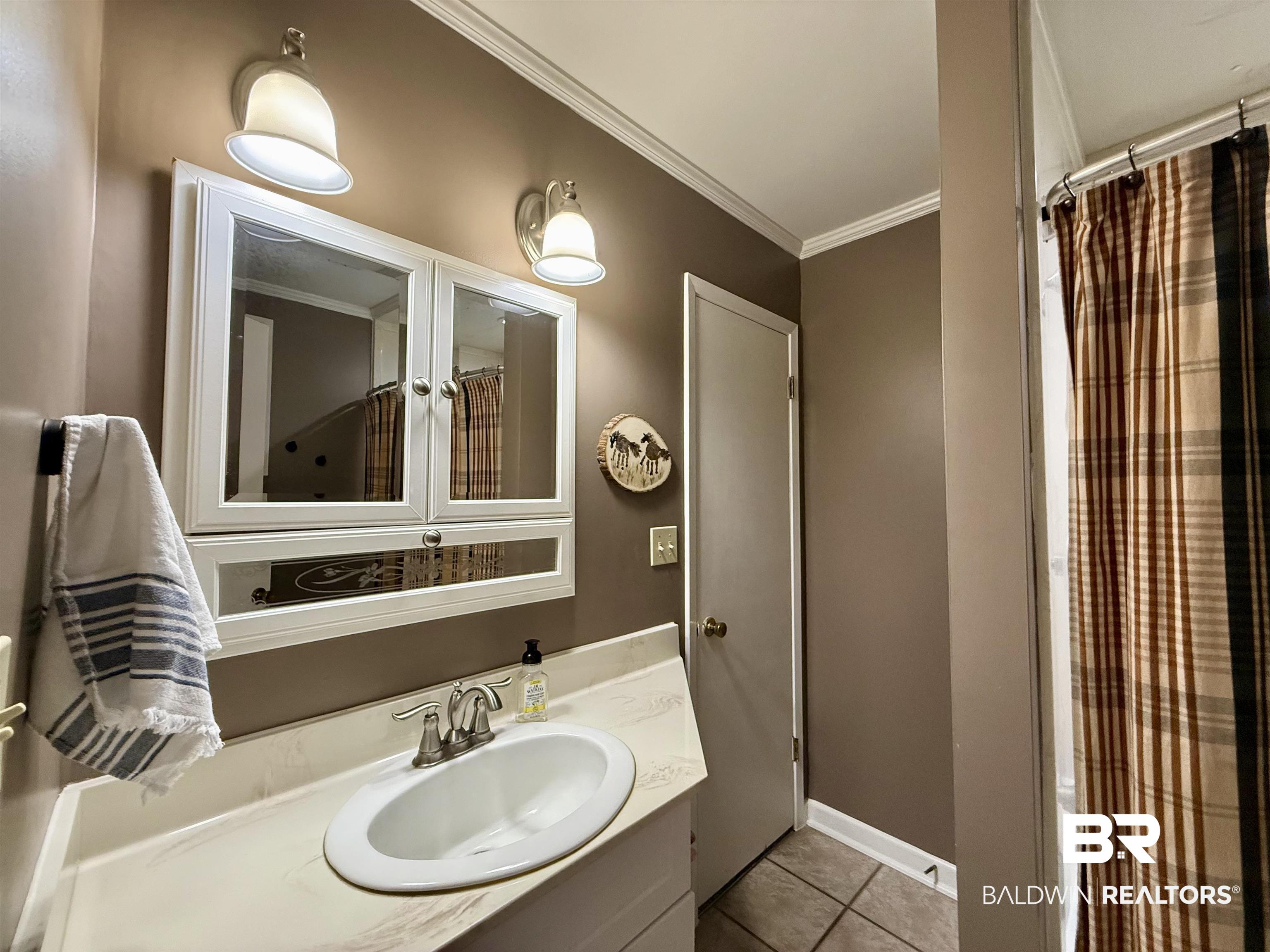 5971 Appleton Road Brewton, AL 36426 - Photo 13 of 23 Bathroom with crown molding, tile patterned flooring, and vanity