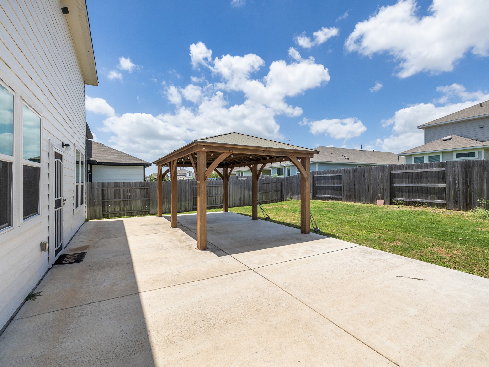 121 Graver Street Georgetown, TX 78626 - Photo 23 of 28 An inviting backyard patio features a spacious concrete area and a charming gazebo, perfect for outdoor entertaining.