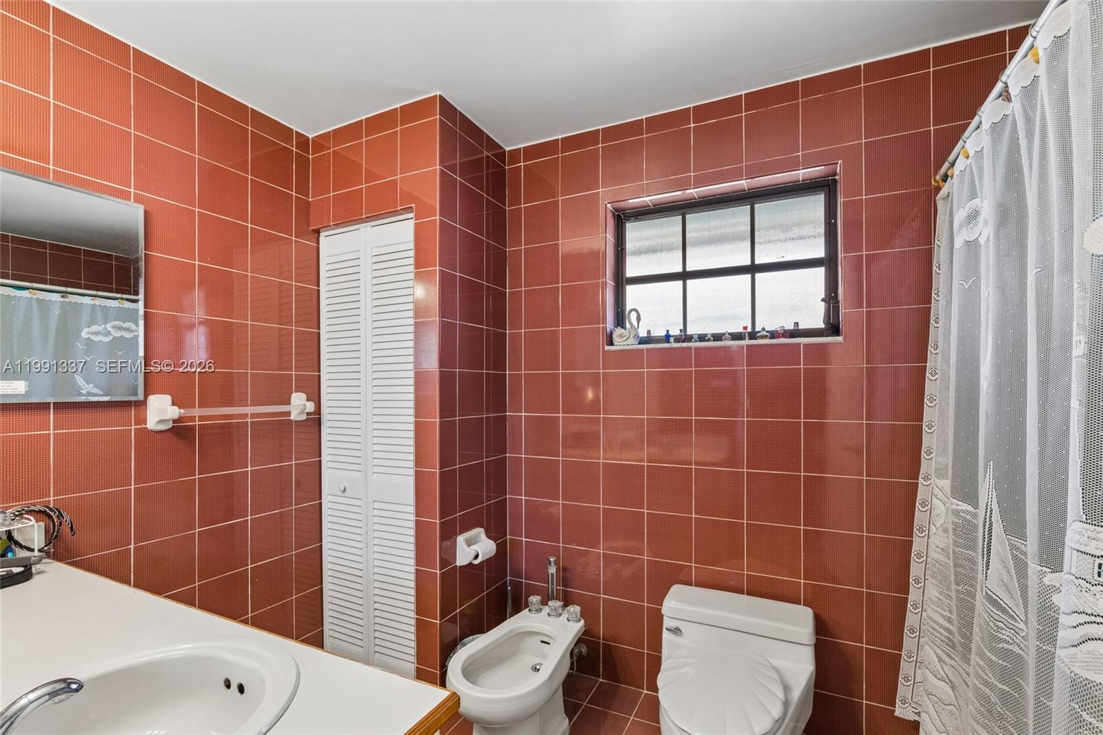 11403 Southwest 129th Place Miami, FL 33186 - Photo 21 of 38 a bathroom with a toilet a sink and a mirror