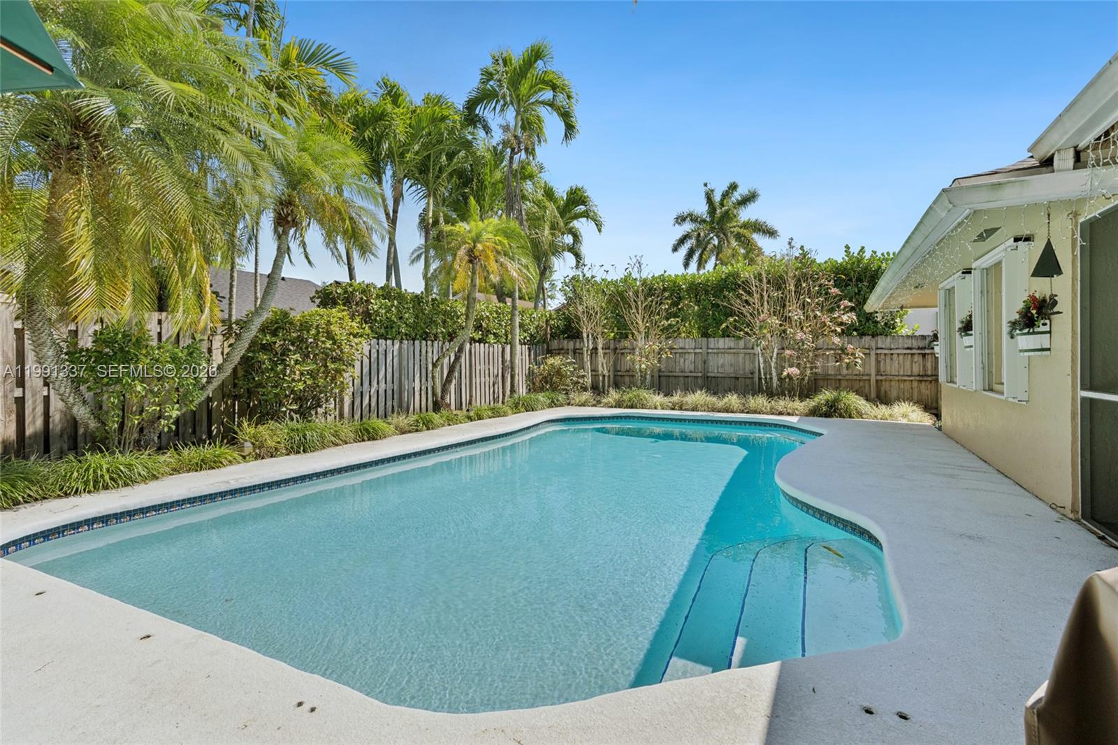 11403 Southwest 129th Place Miami, FL 33186 - Photo 27 of 38 a view of a swimming pool with a garden