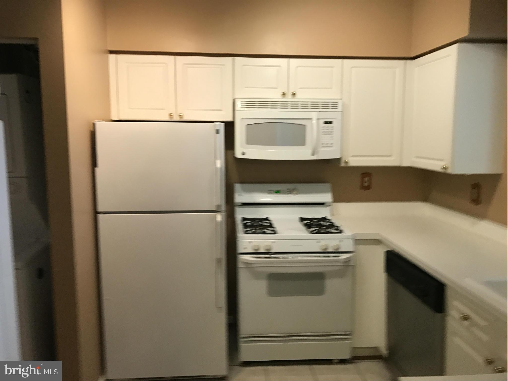 a white refrigerator freezer and a stove sitting inside of a kitchen