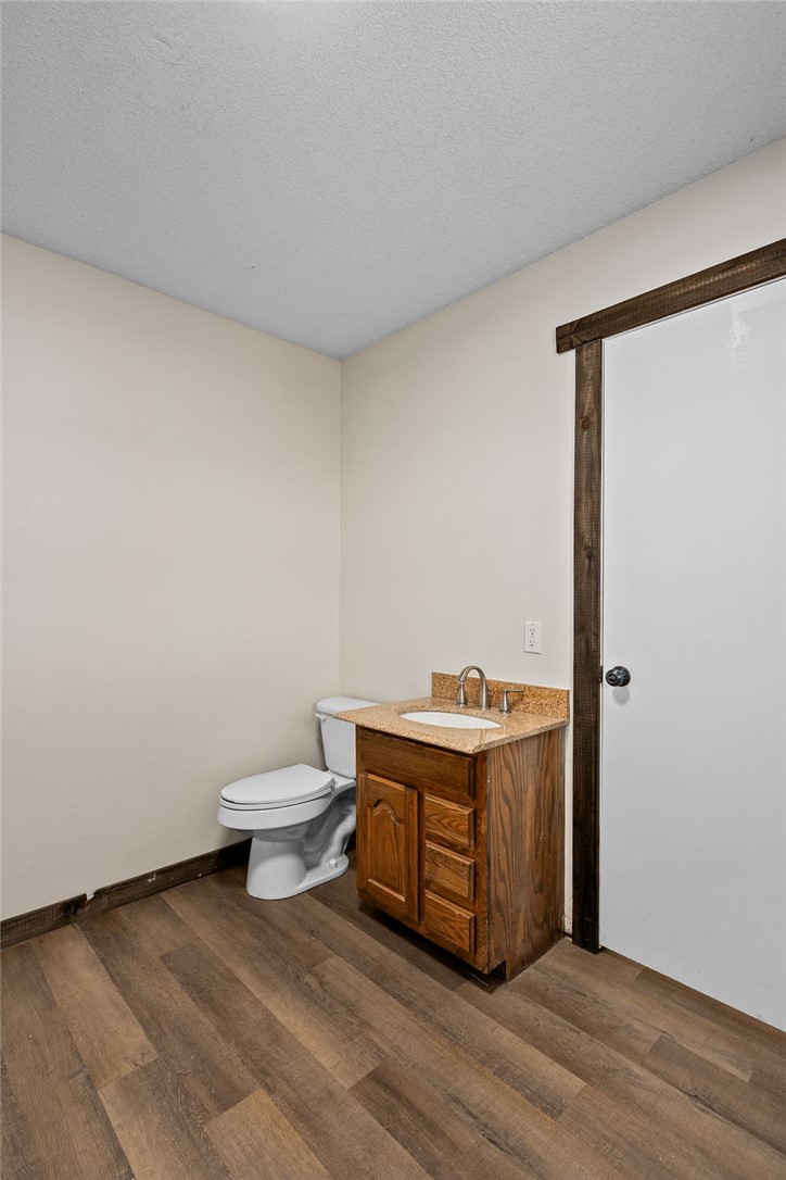 3022 Dow Jones Road Alma, AR 72921 - Photo 17 of 34 Half bath in laundry room with dark wood finished floors, a textured ceiling, and vanity