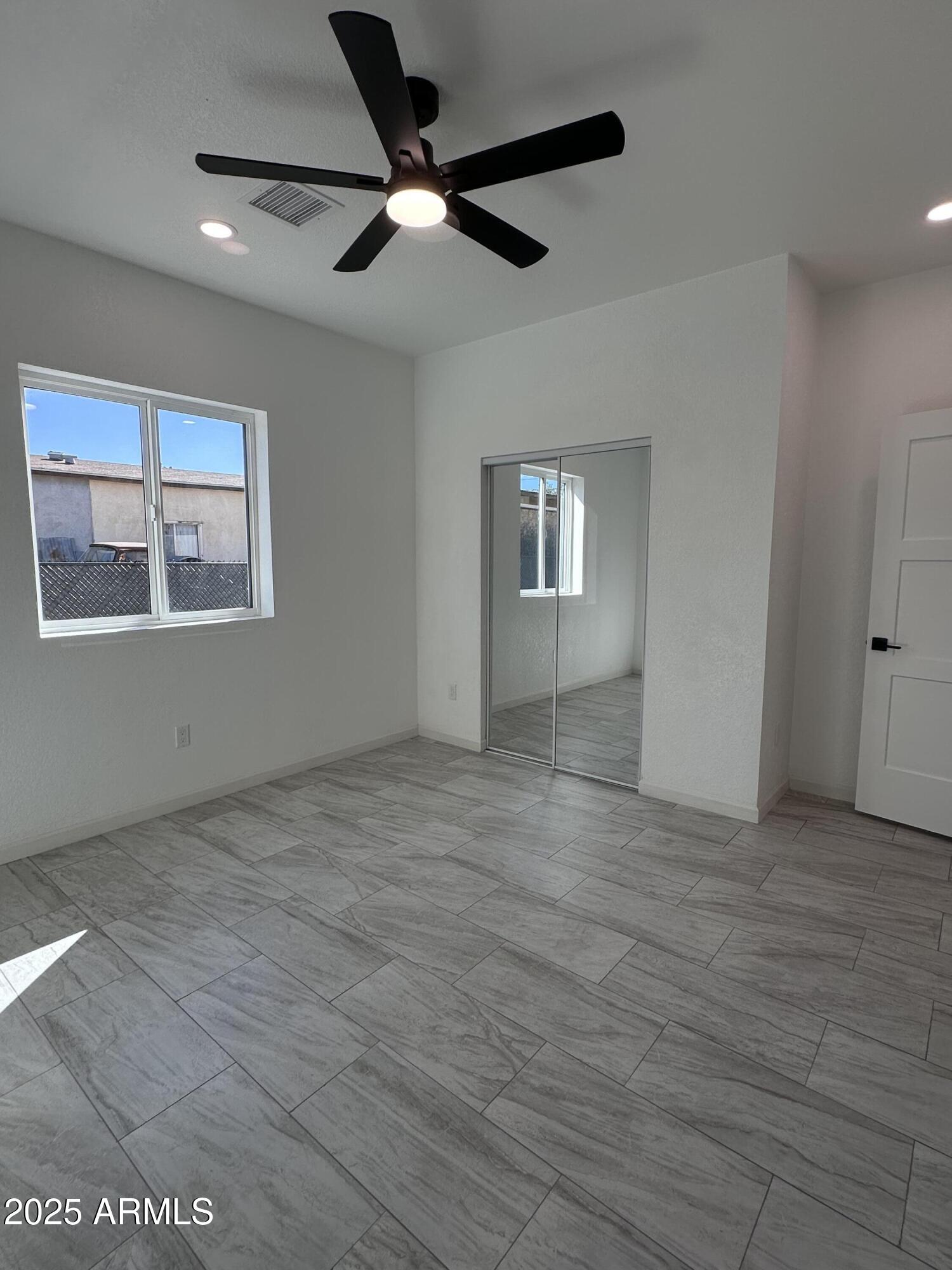 722 East 3rd Street Douglas, AZ 85607 - Photo 12 of 24 an empty room with wooden floor and windows