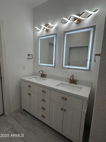 a bathroom with a double vanity sink and a mirror