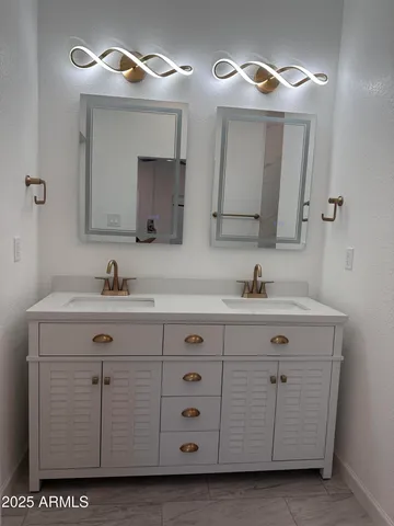 a bathroom with a sink vanity and a mirror
