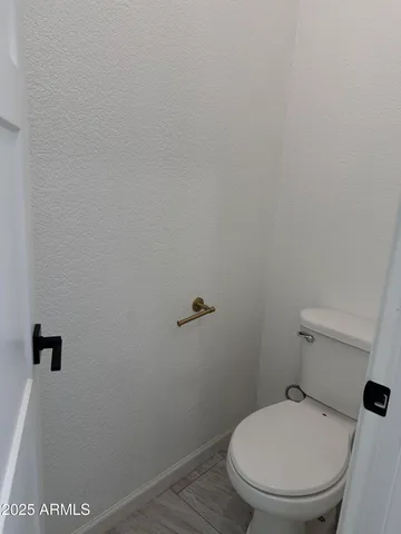 a white toilet sitting next to a wooden wall