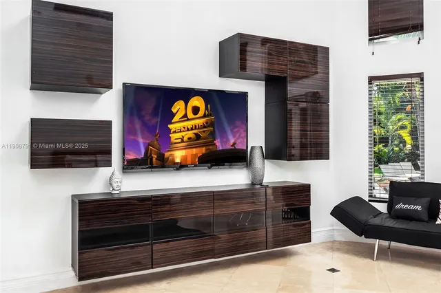 a living room with furniture flat screen tv and appliances