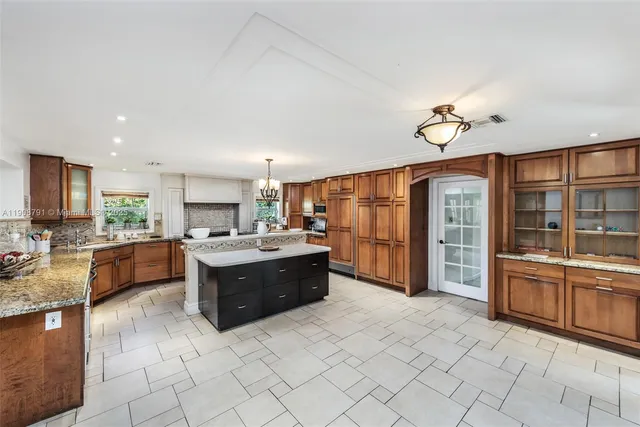 a large kitchen with kitchen island granite countertop a large counter top and stainless steel appliances