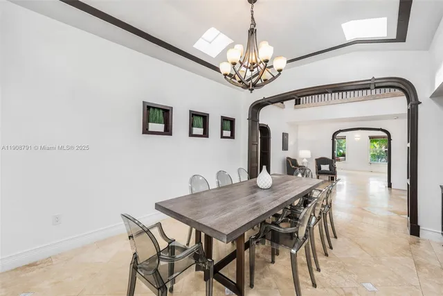 a view of a dining room with furniture a chandelier and wooden floor
