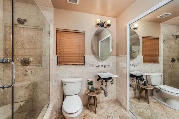 a bathroom with a toilet sink shower and mirror