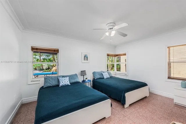 a bedroom with two beds and a window