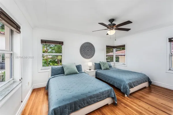 a bedroom with a bed a window and a chandelier