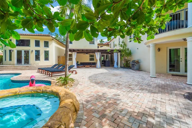 a view of a house with backyard and sitting area