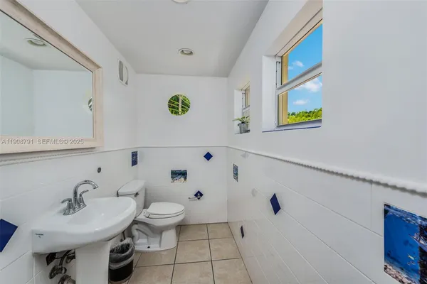 a bathroom with a sink mirror and toilet