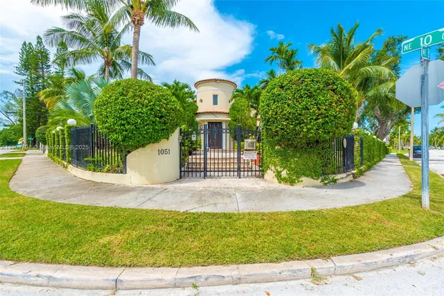 a front view of a house with a garden and trees