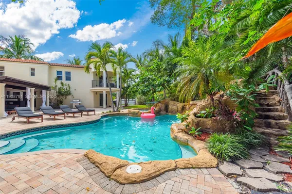 a front view of a house with swimming pool garden and patio