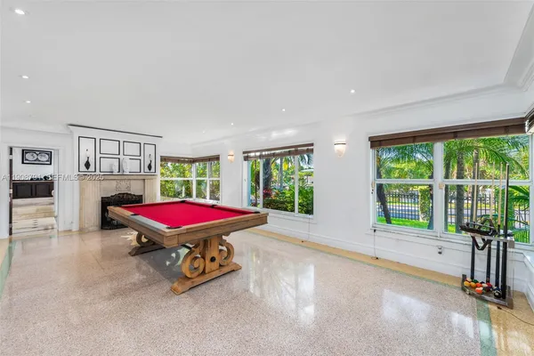 a room with pool table and windows