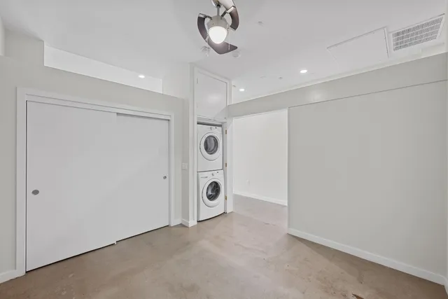 a view of an empty room and chandelier fan