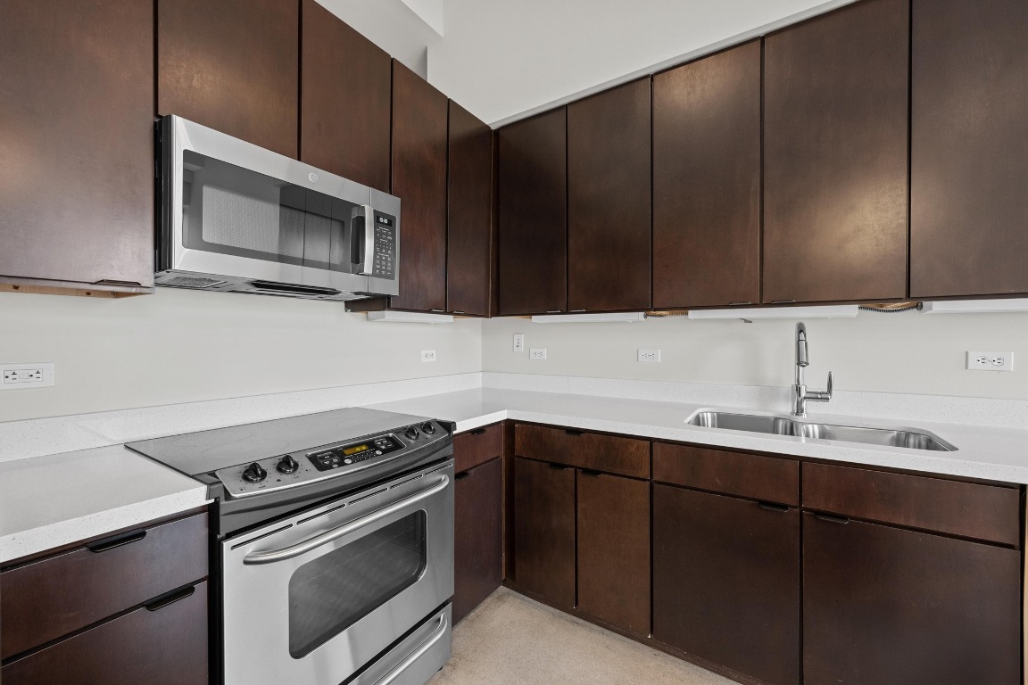 507 Sabine Street, Unit 503 Austin, TX 78701 - Photo 3 of 23 a kitchen with a sink stove and microwave