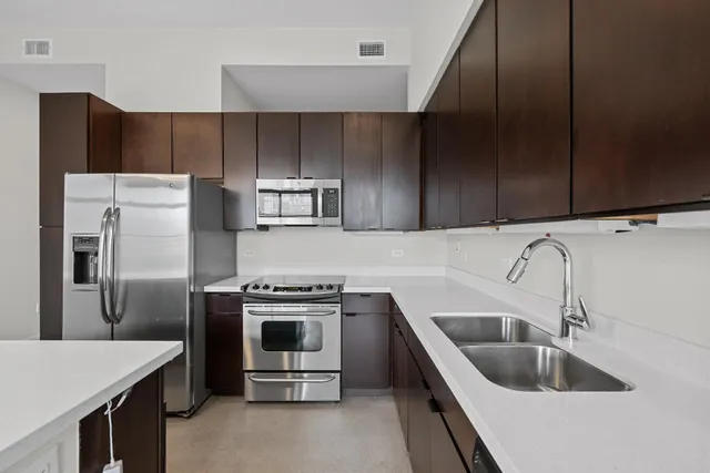 a kitchen with stainless steel appliances granite countertop a sink stove and refrigerator