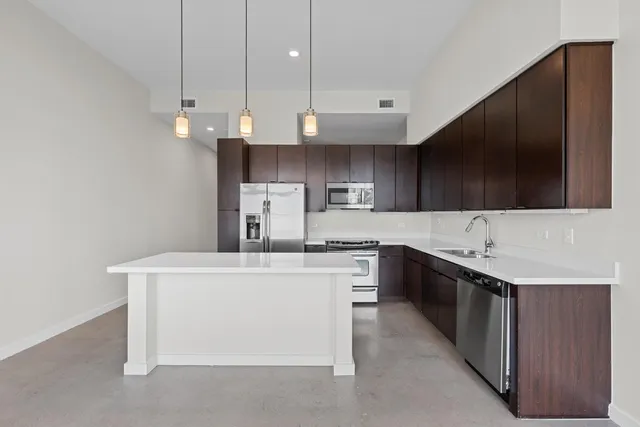 a kitchen with stainless steel appliances a sink a stove and a refrigerator