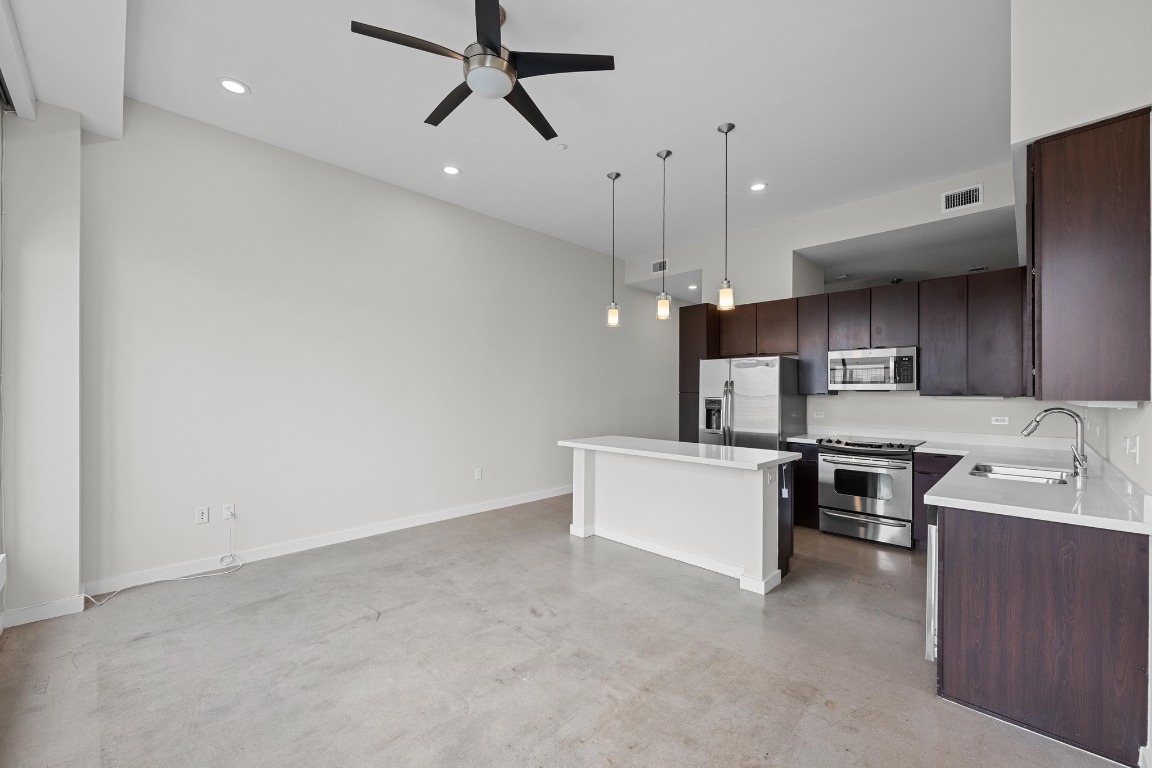507 Sabine Street, Unit 503 Austin, TX 78701 - Photo 7 of 22 a kitchen with stainless steel appliances kitchen island a sink cabinets and wooden floor