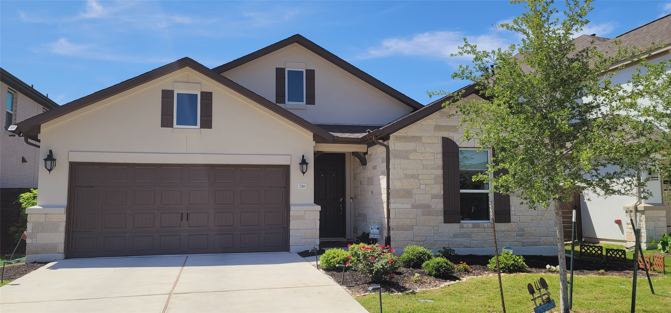 A pristine facade with stone and stucco accents, complementing a manicured landscape.