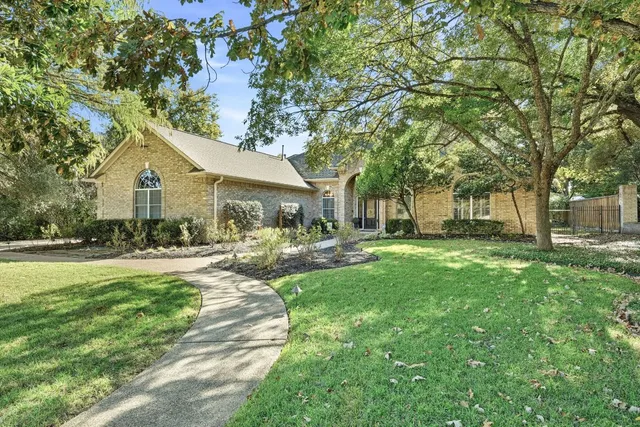 a front view of a house with a garden and trees