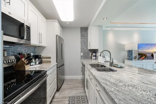 a kitchen with a sink appliances and cabinets