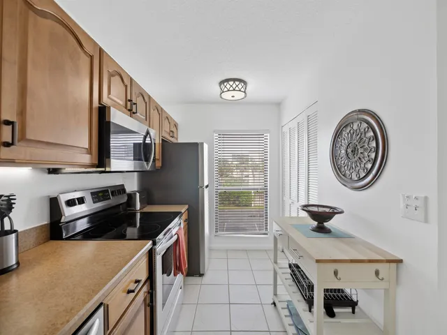 a kitchen with white cabinets and refrigerator