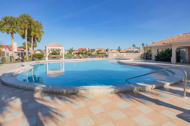 a front view of a house with swimming pool and outdoor seating