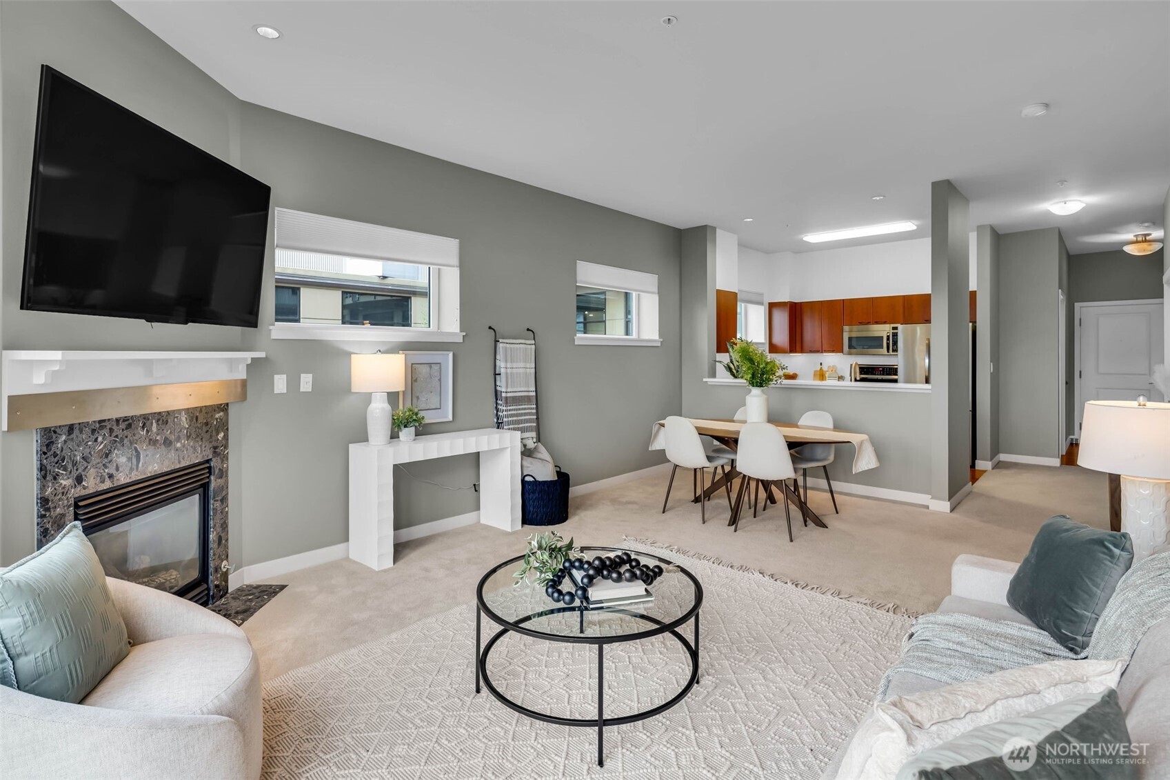 5001 California Avenue Southwest, Unit 103 Seattle, WA 98136 - Photo 12 of 40 a living room with furniture a flat screen tv and kitchen view