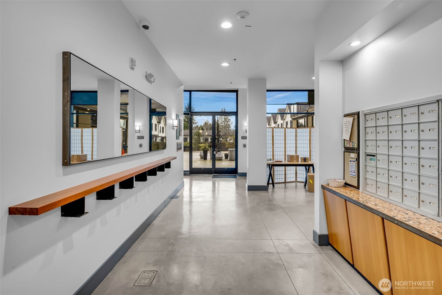 5001 California Avenue Southwest, Unit 103 Seattle, WA 98136 - Photo 6 of 40 a large white kitchen with stainless steel appliances kitchen island granite countertop a refrigerator a stove a dining table and chairs with wooden floor