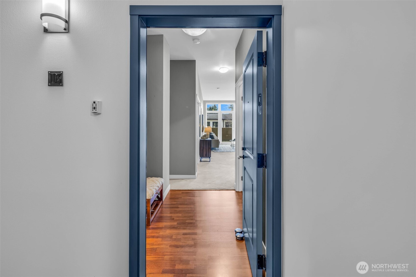 5001 California Avenue Southwest, Unit 103 Seattle, WA 98136 - Photo 7 of 40 a view of a hallway with wooden floor and a bathroom