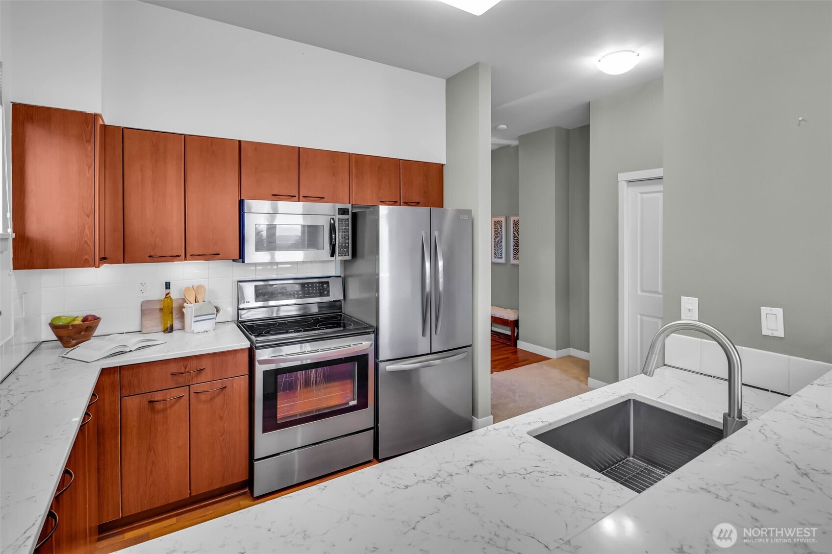 5001 California Avenue Southwest, Unit 103 Seattle, WA 98136 - Photo 9 of 40 a kitchen with stainless steel appliances kitchen island granite countertop a refrigerator and a sink