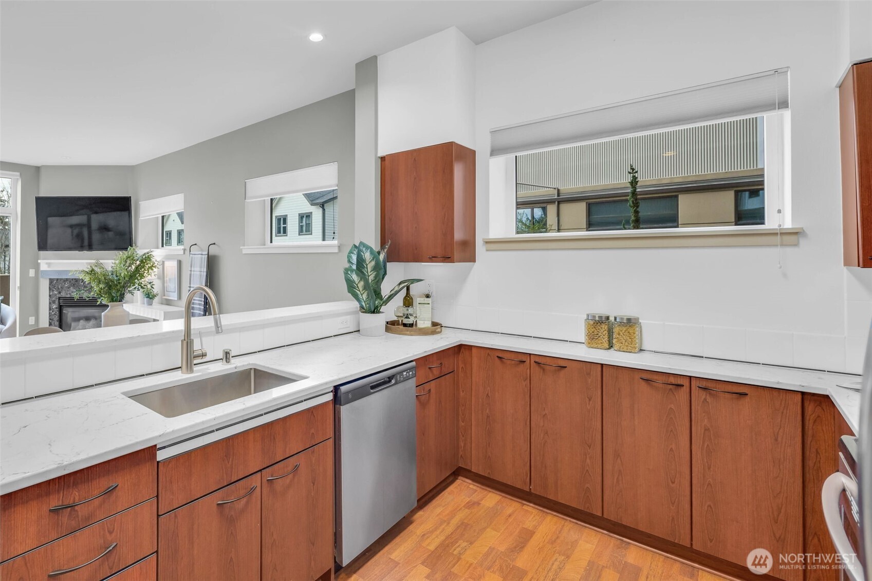 5001 California Avenue Southwest, Unit 103 Seattle, WA 98136 - Photo 10 of 40 a kitchen with stainless steel appliances granite countertop a sink dishwasher and cabinets with wooden floor