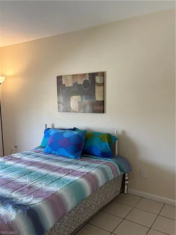 a bedroom with a bed and painting on the wall