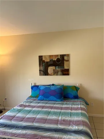 a bedroom with a bed and a potted plant