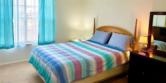 a bedroom with a bed next to a window