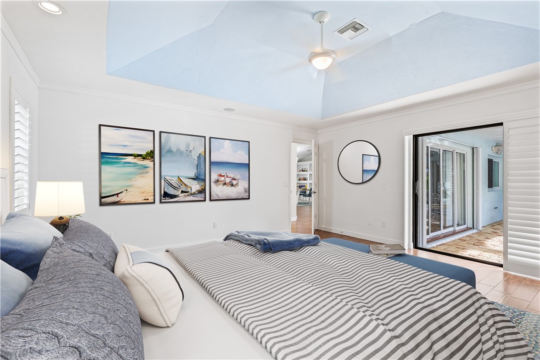 1939 Ocean Ridge Circle Vero Beach, FL 32963 - Photo 12 of 33 a bedroom with a large bed and a chandelier