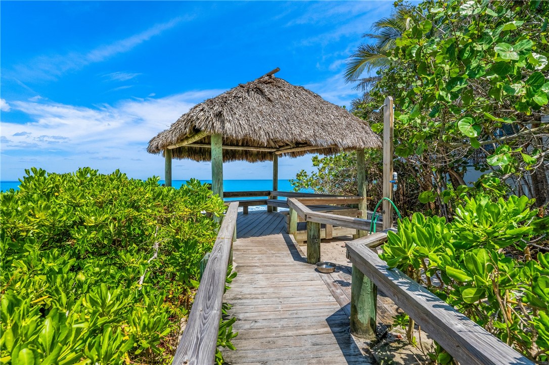 1939 Ocean Ridge Circle Vero Beach, FL 32963 - Photo 31 of 33 a view of a patio with table and chairs under an umbrella with potted plants