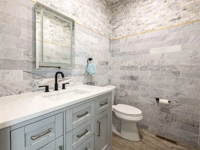 a bathroom with a sink a toilet and a window