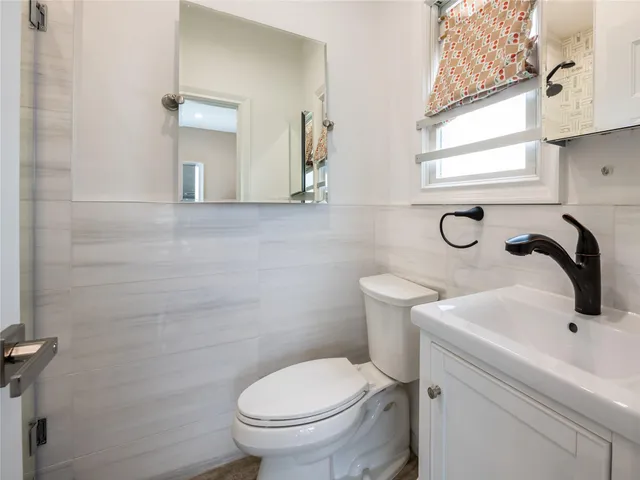 a bathroom with a sink a toilet and a mirror